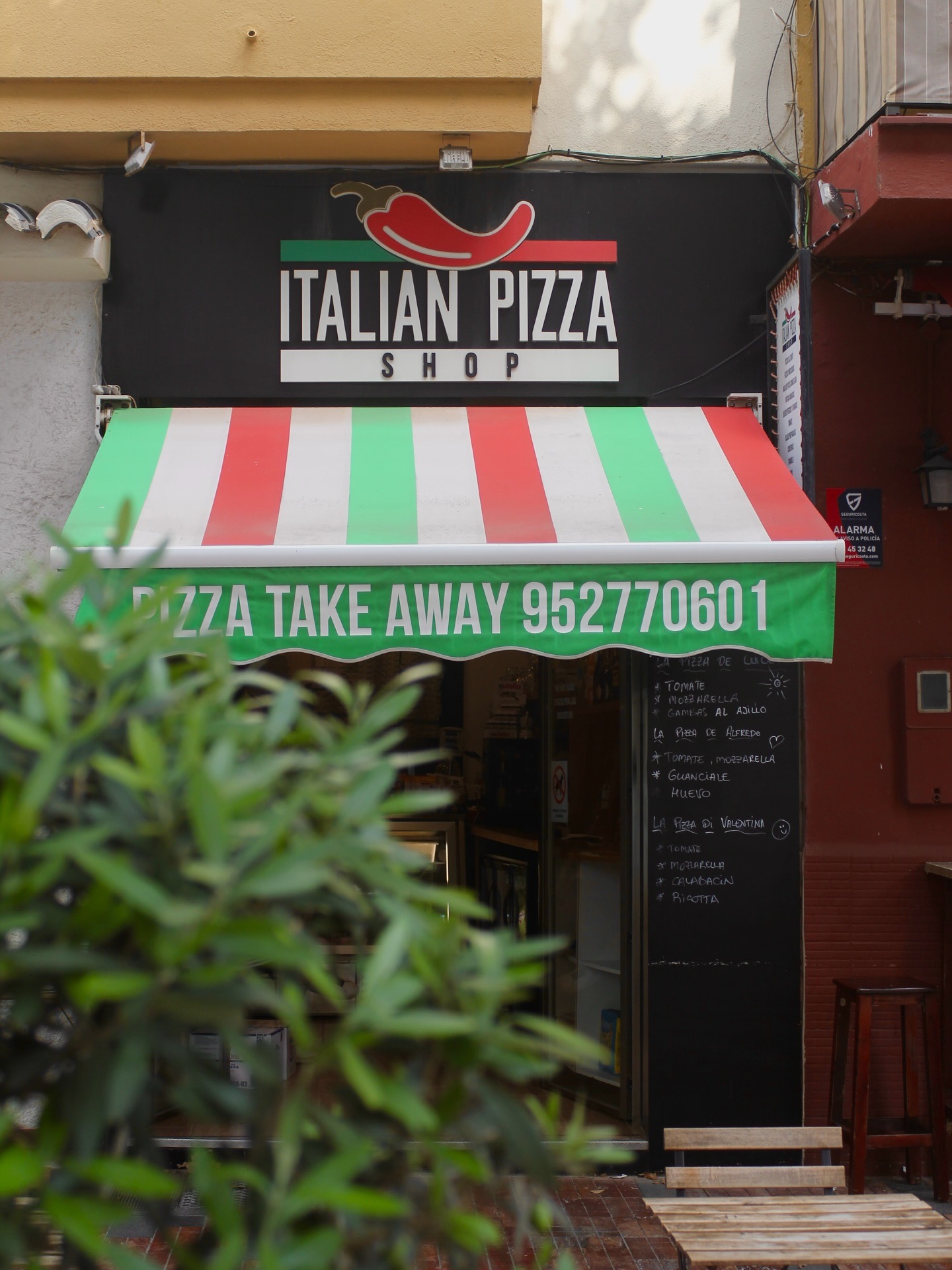 Italian Pizza Shop storefront with red white and green awning