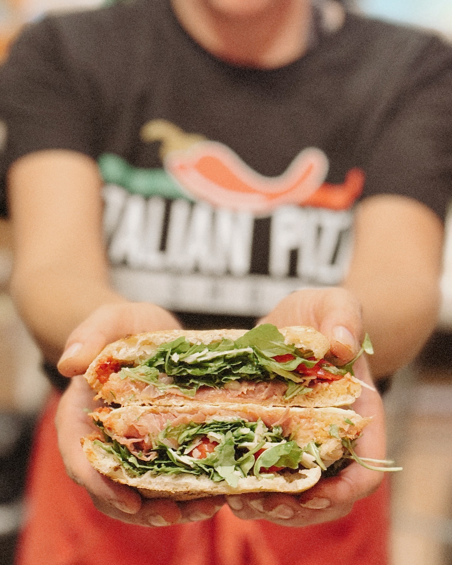 Fresh panuozzo sandwich held up to camera